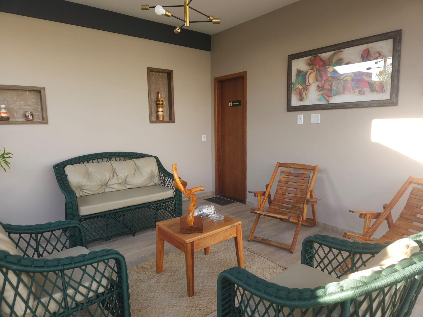Sala externa coberta com poltronas e decoração